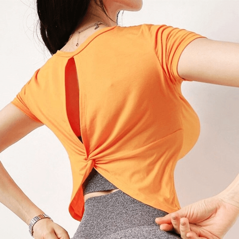 Stylish women's open-back sports top in orange, short sleeves, perfect for yoga, featuring breathable, quick-dry fabric.